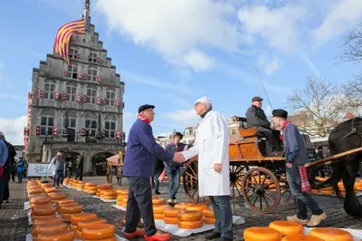 two men shaking hands in front of a carriage of pumpkins at B&B De Beijersche Stee , Logies in de Wagenschuur in Stolwijk