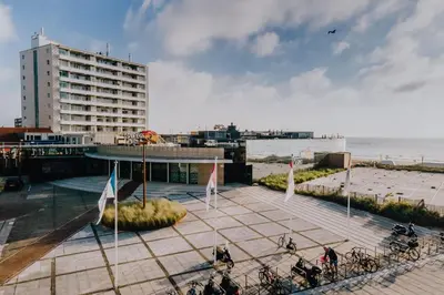 a group of people riding bikes on a sidewalk near the beach at De Schelp 85 in Zandvoort