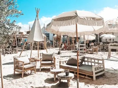 a group of chairs and umbrellas on a beach at La Siesta Noordwijk Zee in Noordwijk